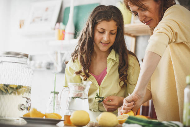 istock Woman squeezing lemon and making lemonade with her daughter 1148520763