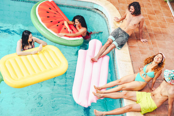 istock Happy friends having fun in swimming pool during summer tropical 1148521669