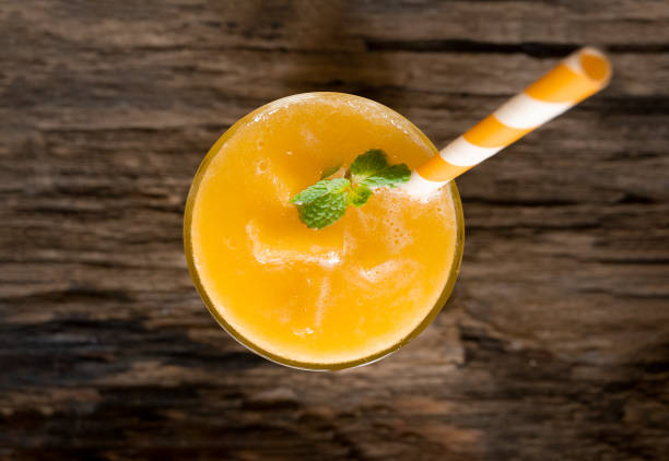 istock Mango smoothies, juice and fruit mango drink in a glass drink orange colorful fruit juice milkshake blend beverage healthy high protein the taste yummy in glass on wood background from the top view. 1148522702