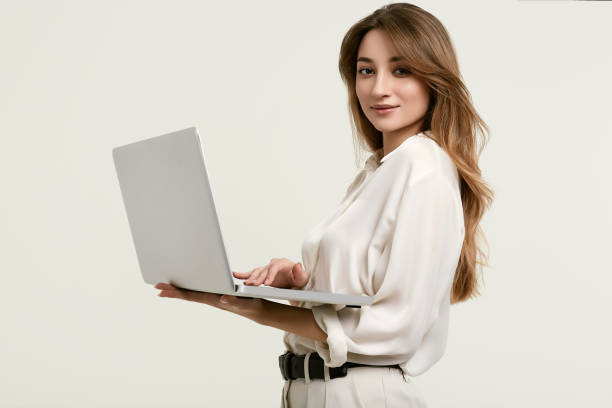 istock Gorgeous brunette model posing in white clothes with laptop 1148523281