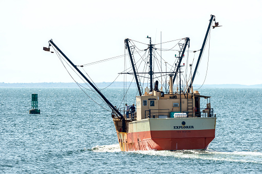 New Bedford, Massachusetts, USA - May 8, 2019: Eastern rig fishing vessel Explorer beginning to lower her outriggers on her way out of New Bedford