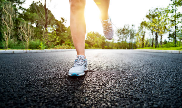 istock Woman legs running on asphalt road 1148525523