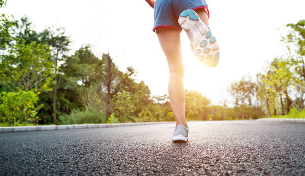 istock Woman legs running on asphalt road 1148526058