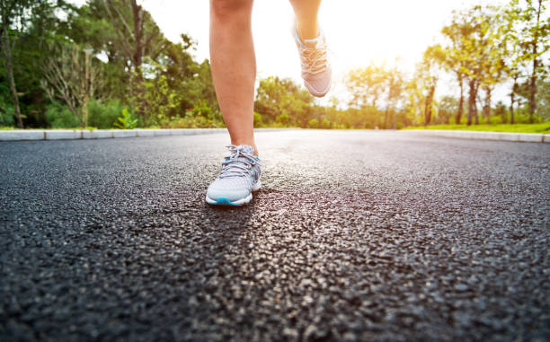 istock Woman legs running on asphalt road 1148526117