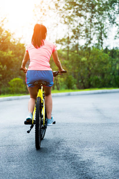istock Young asian woman taking a bicycle riding in park. 1148526264