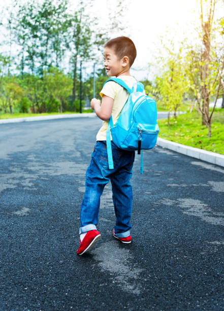 Radiating enthusiasm and dressed in a vibrant turquoise T-shirt, a cheerful teen boy stands ready for school with a backpack in hand. His joyful expression reflects a genuine love for learning as he embraces the excitement of a new day. The warm glow of late daytime enhances the scene, casting a positive light on this junior adventurer's journey into the world of education. This image captures the spirit of youthful exuberance and the anticipation of new discoveries in the school environment.