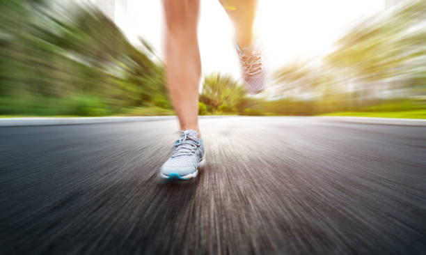 istock Woman legs running on asphalt road 1148526344