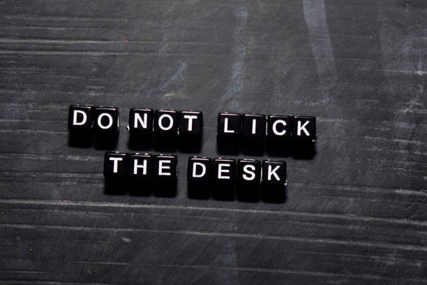 don't lick the desk on wooden blocks. education, motivation and inspiration concept - single word love wood typescript imagens e fotografias de stock