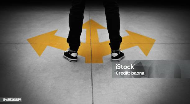 Young Man Feet And Three Yellow Arrows Painted On Floor Stock Photo - Download Image Now