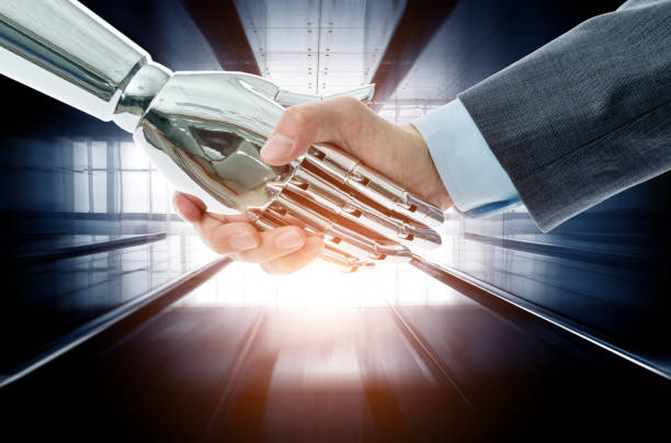 istock Businessman and robot shaking hands on modern office corridor background 1148531676