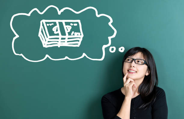 Woman dreaming about money in front of blackboard.
