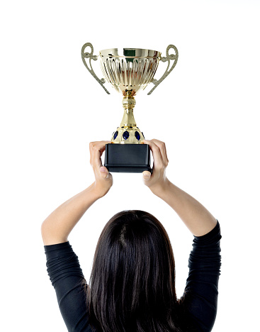 Woman hand holding a golden trophy.