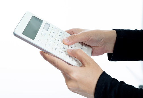 Woman hand holding calculator on white background.