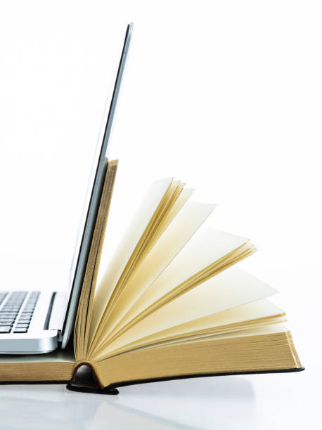 istock Laptop and open book on white background 1148535768