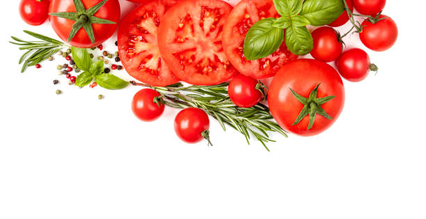 Creative border made of  fresh vegetables, herbs and spices. Various colorful tomatoes and basil leaves isolated on white background.  Flat lay. Top view"n