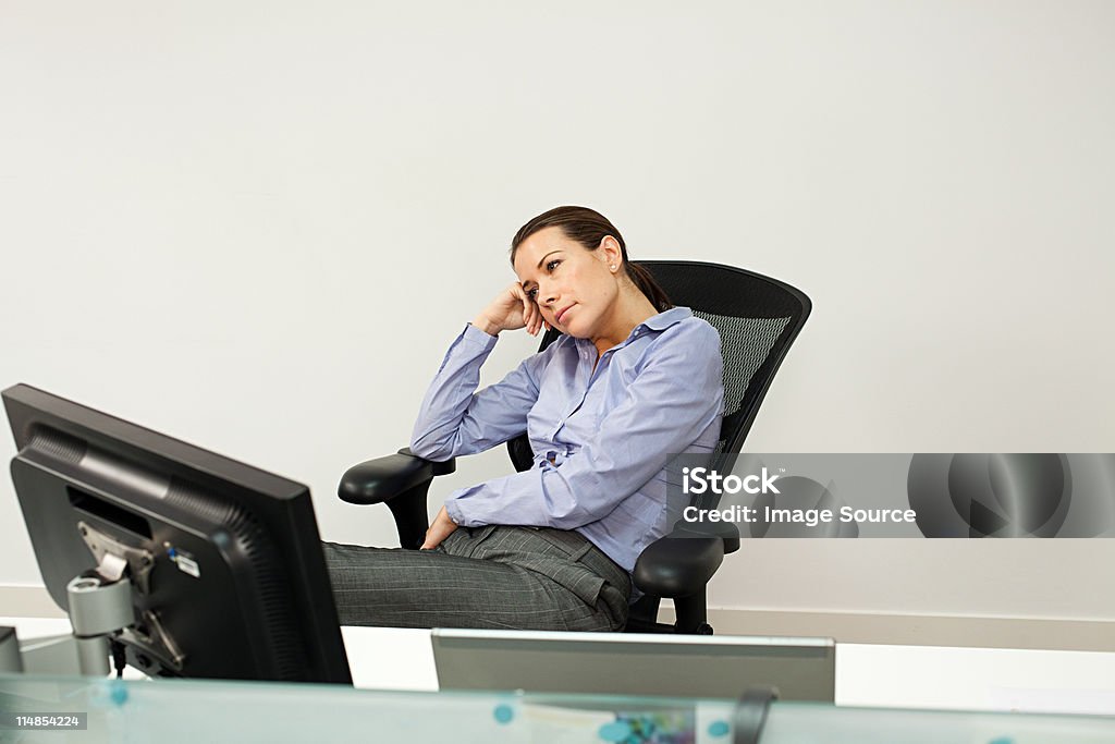 Bored businesswoman in office  25-29 Years Stock Photo