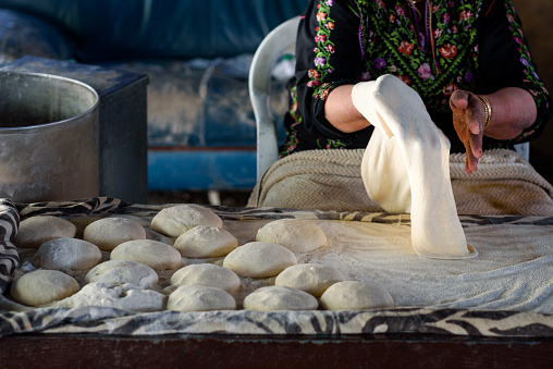 Close up of old Arab woman hands kneading fresh dough for Taboon bread or Lafah is a Middle Eastern flatbread also called lafa or Iraqi pita.