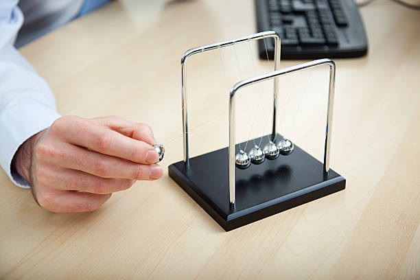Office worker playing with newtons cradle  desk toy stock pictures, royalty-free photos & images