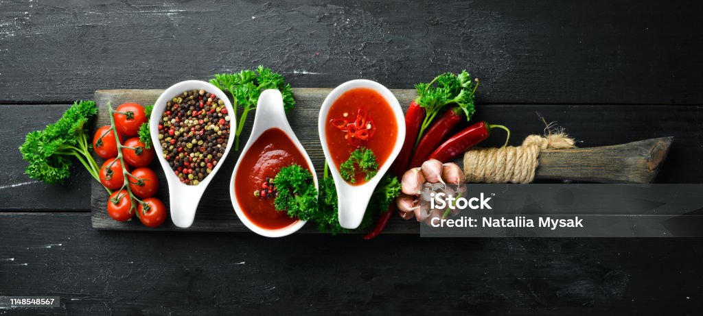 Set of red sauces on a wooden background. Ketchup, barbecue sauce, tomato sauce. Top view. Free space for your text. Barbecue - Meal Stock Photo