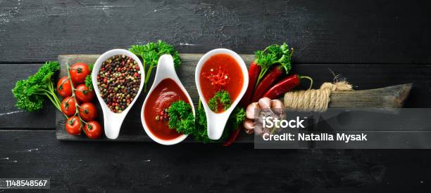 Set Of Red Sauces On A Wooden Background Ketchup Barbecue Sauce Tomato Sauce Top View Free Space For Your Text Stock Photo - Download Image Now