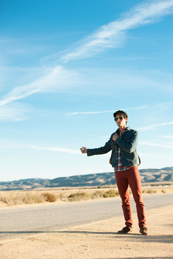 istock Young man hitchhiking at roadside 114854859