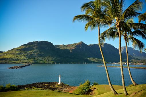 Tranquil Nawiliwili Harbor on a calm morning, viewed from a public walking path the travels around the harbour. The protected bay is where cruise ships dock, and adjacent Kalapaki Beach is a popular spot for swimming, stand up paddle boarding and sunbathing.