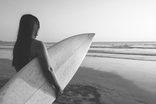 istock woman with surfboard on beach 1148552346