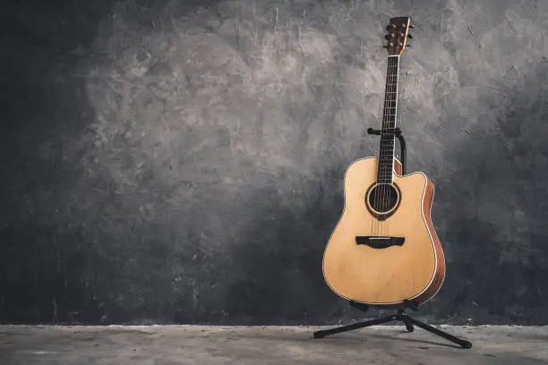 Photo of acoustic guitar on gray wall background