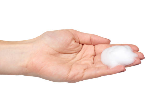 istock Hand with white foam bubbles, beauty smooth mousse, close up photo. 1148557202