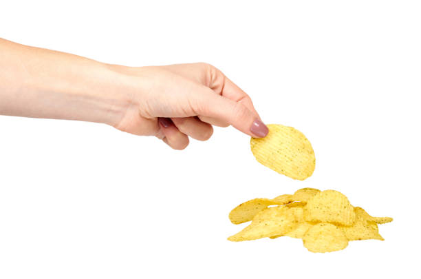istock Hand with golden color potato chips, crunchy and wavy. 1148557222