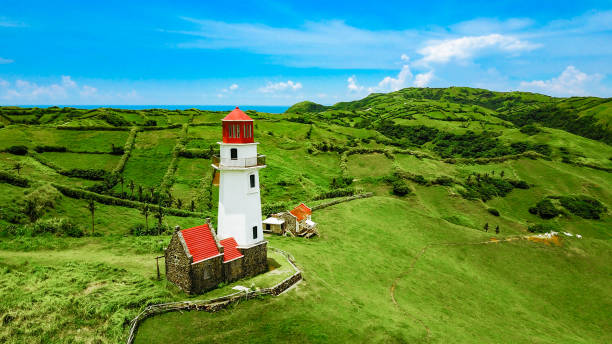 Drone shot of Mahatao Tayid Lighthouse on top rolling hills in the province of Batanes, Philippines stock photo
