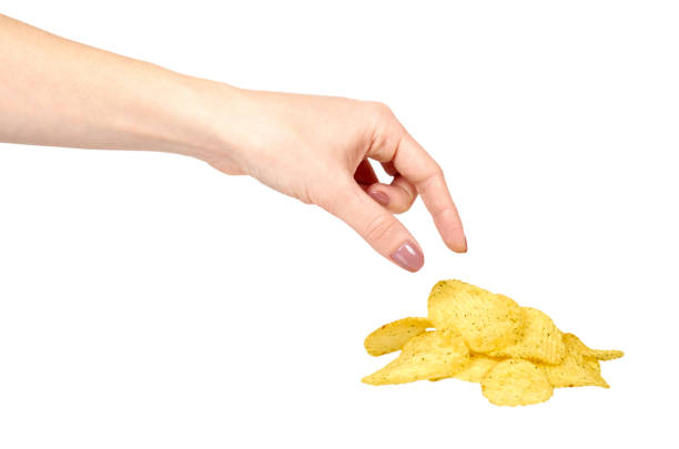 istock Hand with golden color potato chips, crunchy and wavy. 1148557278