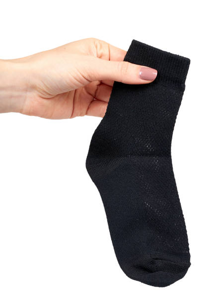 istock Hand with black cotton sock, foot clothing. 1148557962