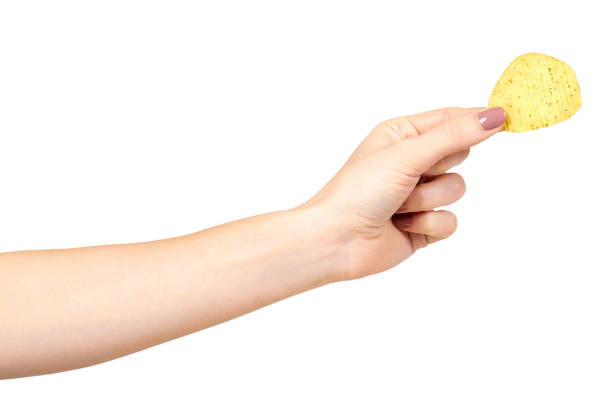 istock Hand with golden color potato chips, crunchy and wavy. 1148557974