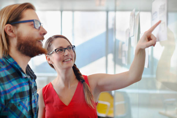 istock Woman pointing to layouts talking with colleague 1148558885