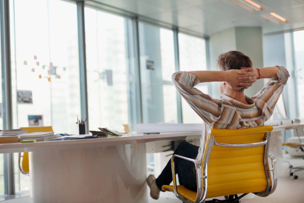 Man sitting in design office looking out of window