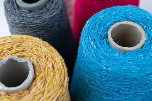 Close up of thread spindles of different color used in stitching clothes