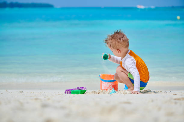 istock Three year old toddler playing on beach 1148561974