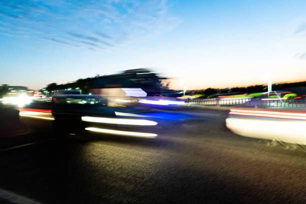 Bus driving on highway at dusk.