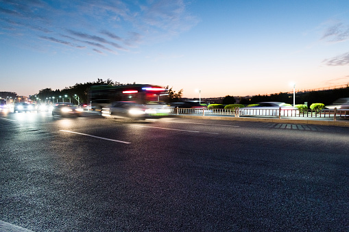 Cars driving on highway at dusk.