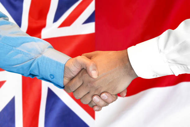 istock handshake on UK and Monaco flag background. 1148564580