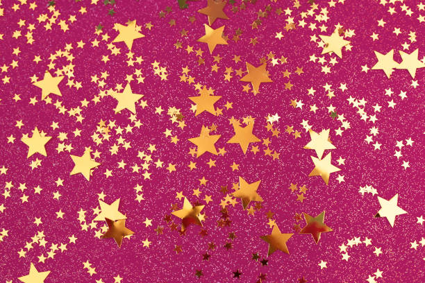 istock Golden stars confetti on pink background. 1148565247