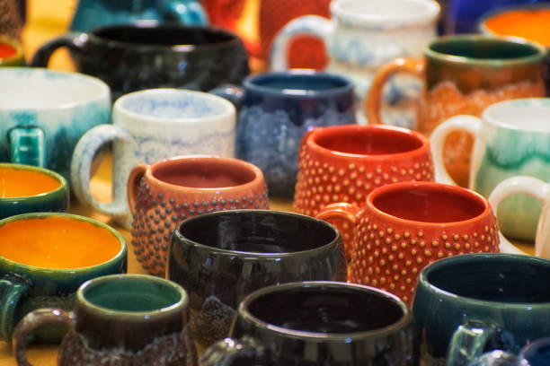 istock Colorful ceramic cups on the shelf. Pottery unusual design. 1148569079
