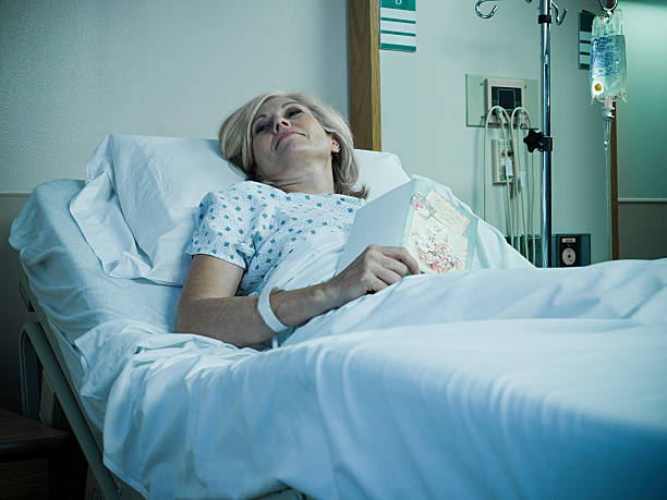 Mature woman lying in hospital bed  hospital card stock pictures, royalty-free photos & images