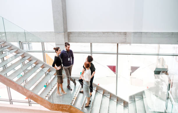 istock Group of young businesspeople standing on a staircase, talking. 1148580279