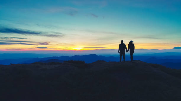 istock The couple standing on the mountain on the sunset background 1148587397