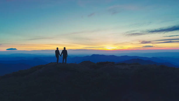 istock The couple standing on the mountain on the sunset background 1148587447