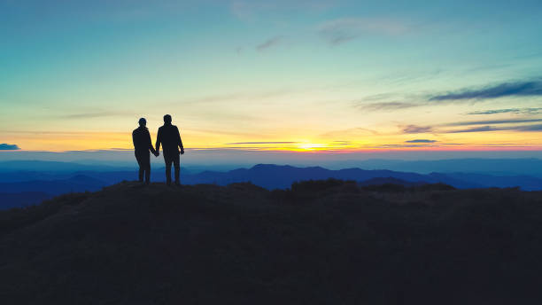 istock The couple standing on the mountain on the sunset background 1148587482