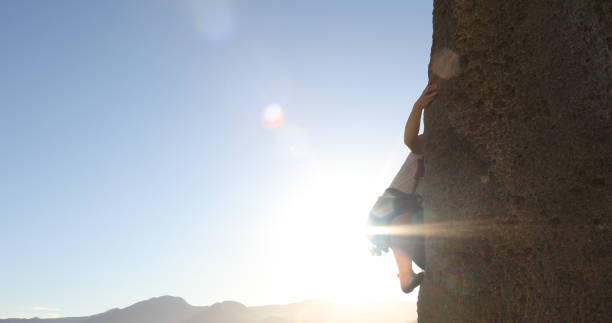 istock Female mountain climber makes her way up rock face 1148588645