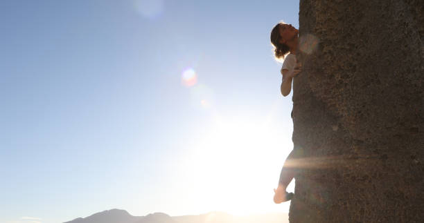istock Female mountain climber makes her way up rock face 1148588677